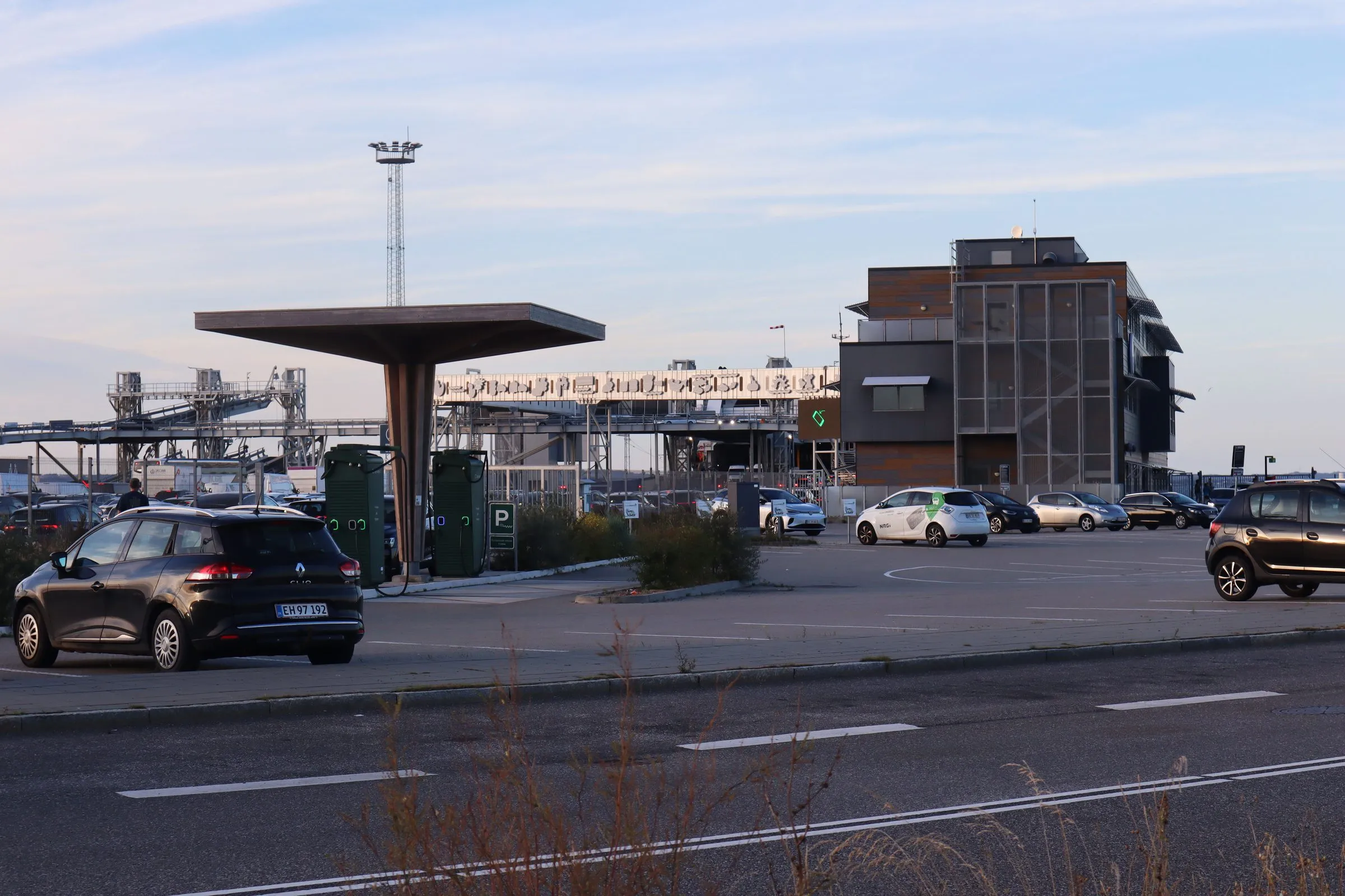 De parkeerplaats bij de veerbootterminal in Aarhus met de havengebouwen erachter