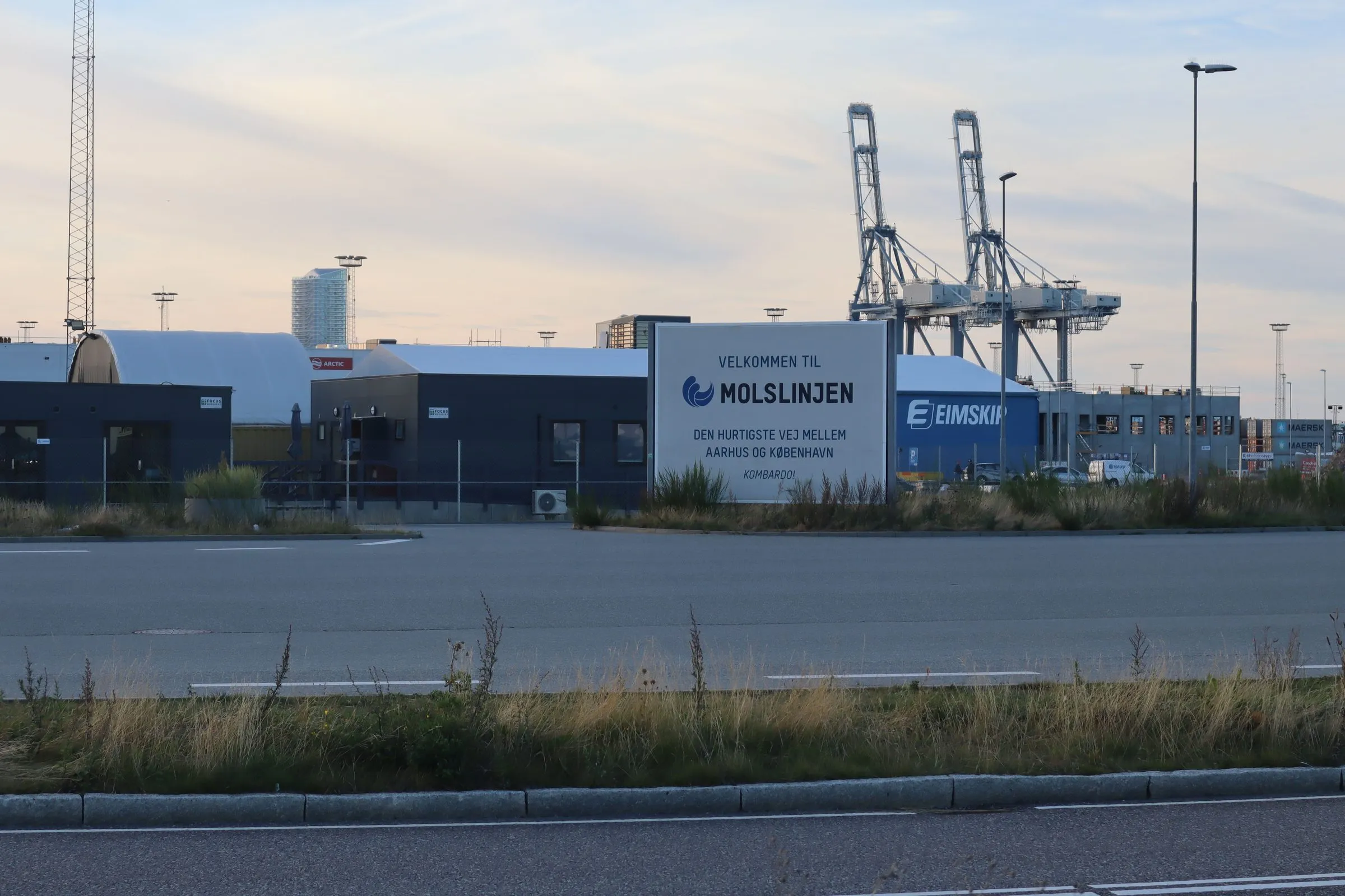 En skylt från Molslinjen vid terminalen i Aarhus med containerkranar i bakgrunden