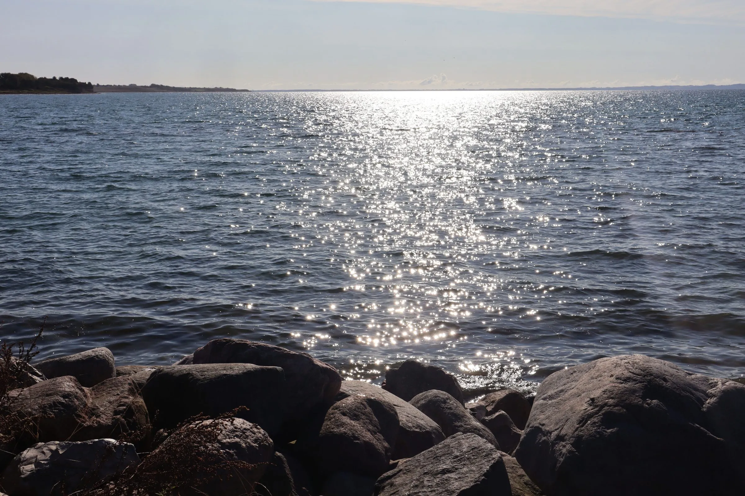 Sunlight glittering on the water over rocks at the edge of the Kattegat