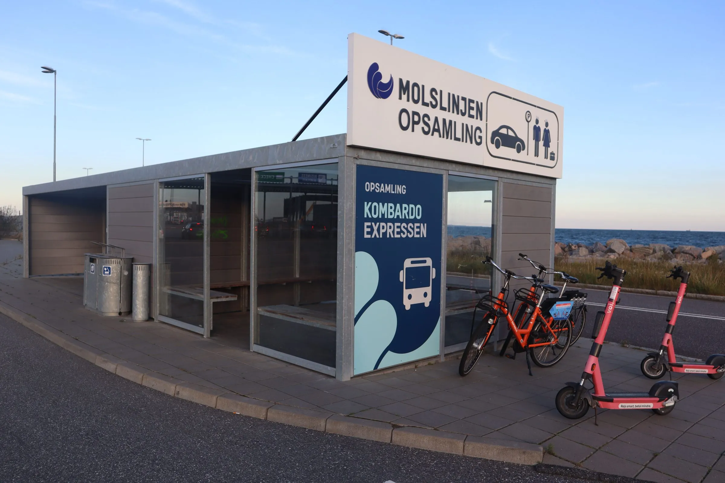 The Kombardo Expressen pick-up shelter at the ferry port with bicycles and scooters parked beside it