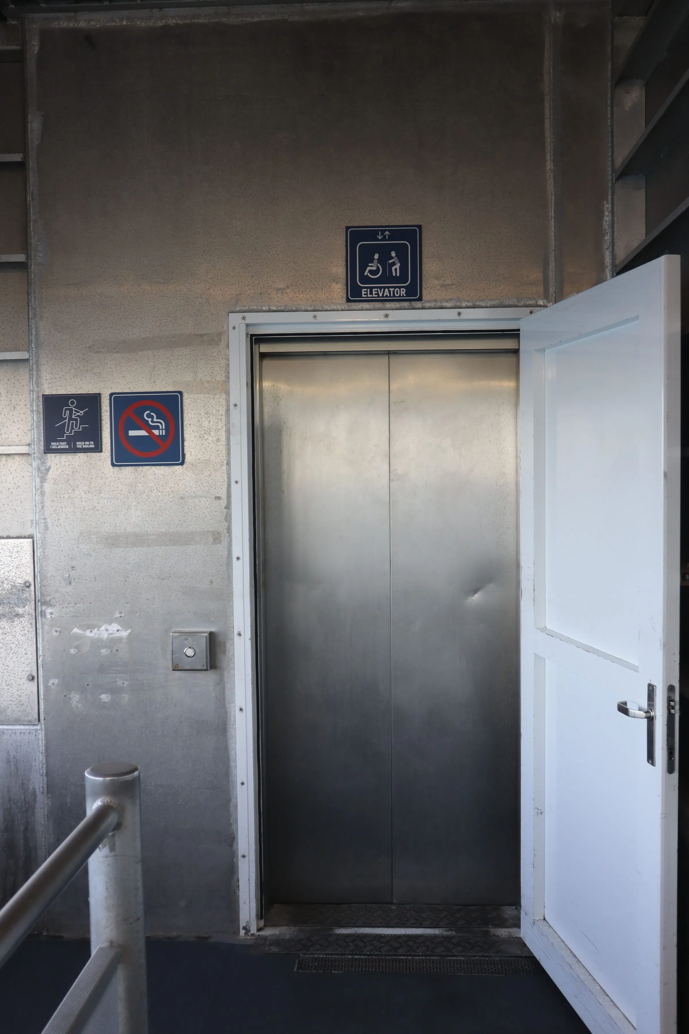 The lift door on the car deck with accessibility signage beside it