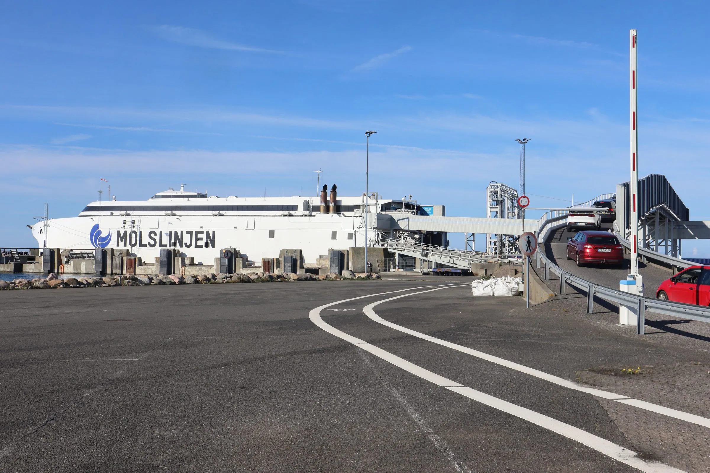 Een auto rijdt in Odden de klep op vanaf de veerboot, met de loopbrug erboven