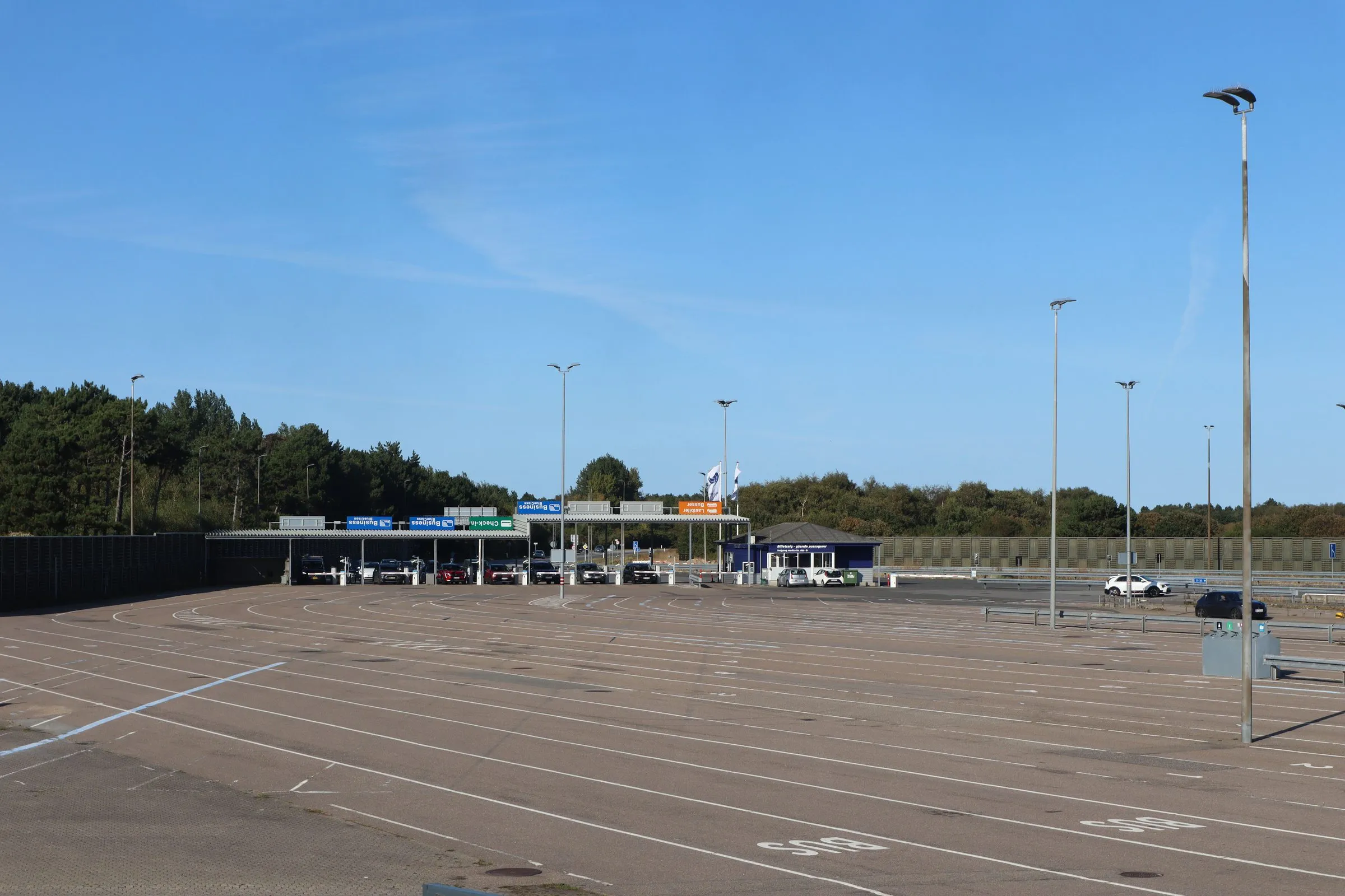 De brede lege opstelstroken in Odden met naaldbos achter de check-in-hokjes