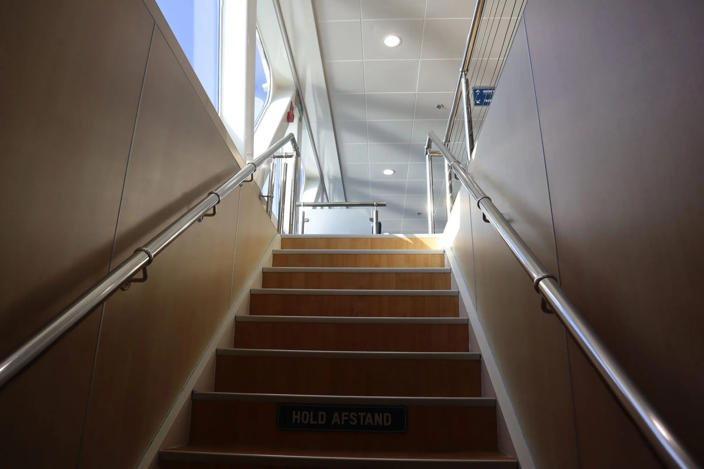 A staircase with handrails leading up from the car deck to the passenger deck
